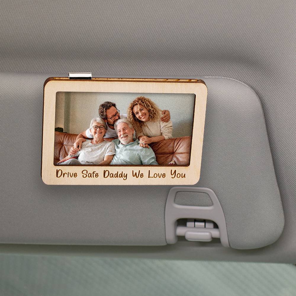 Personalized MadeMine magnetic car sun visor clip with photo frame accessory, holding a family photo on a car sun visor.