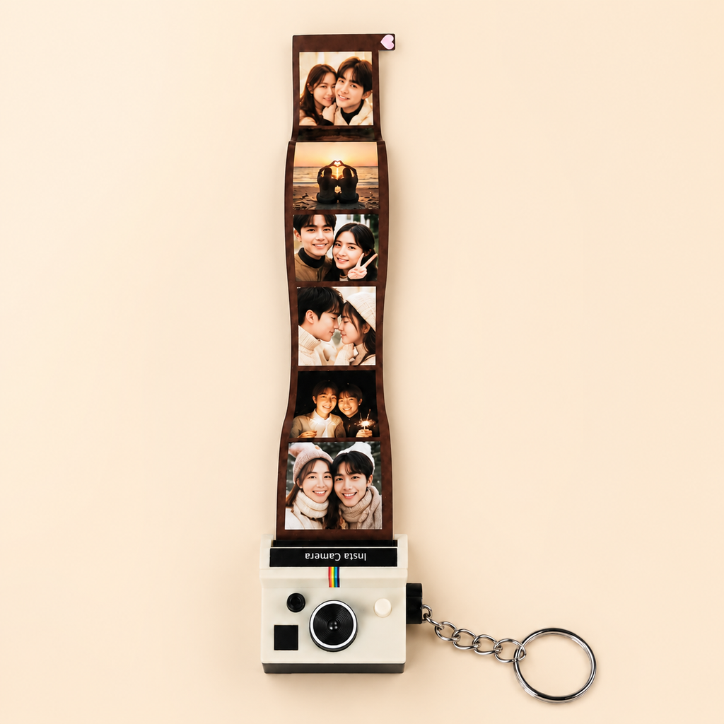 A custom instant film photo strip keychain featuring five printed photos of a couple, attached to a retro-style Polaroid camera keychain with a silver metal ring, set against a solid beige background.