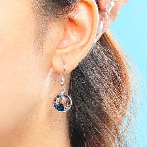 Custom photo drop earrings by MadeMine featuring personalized photo charms hanging from silver earrings.
