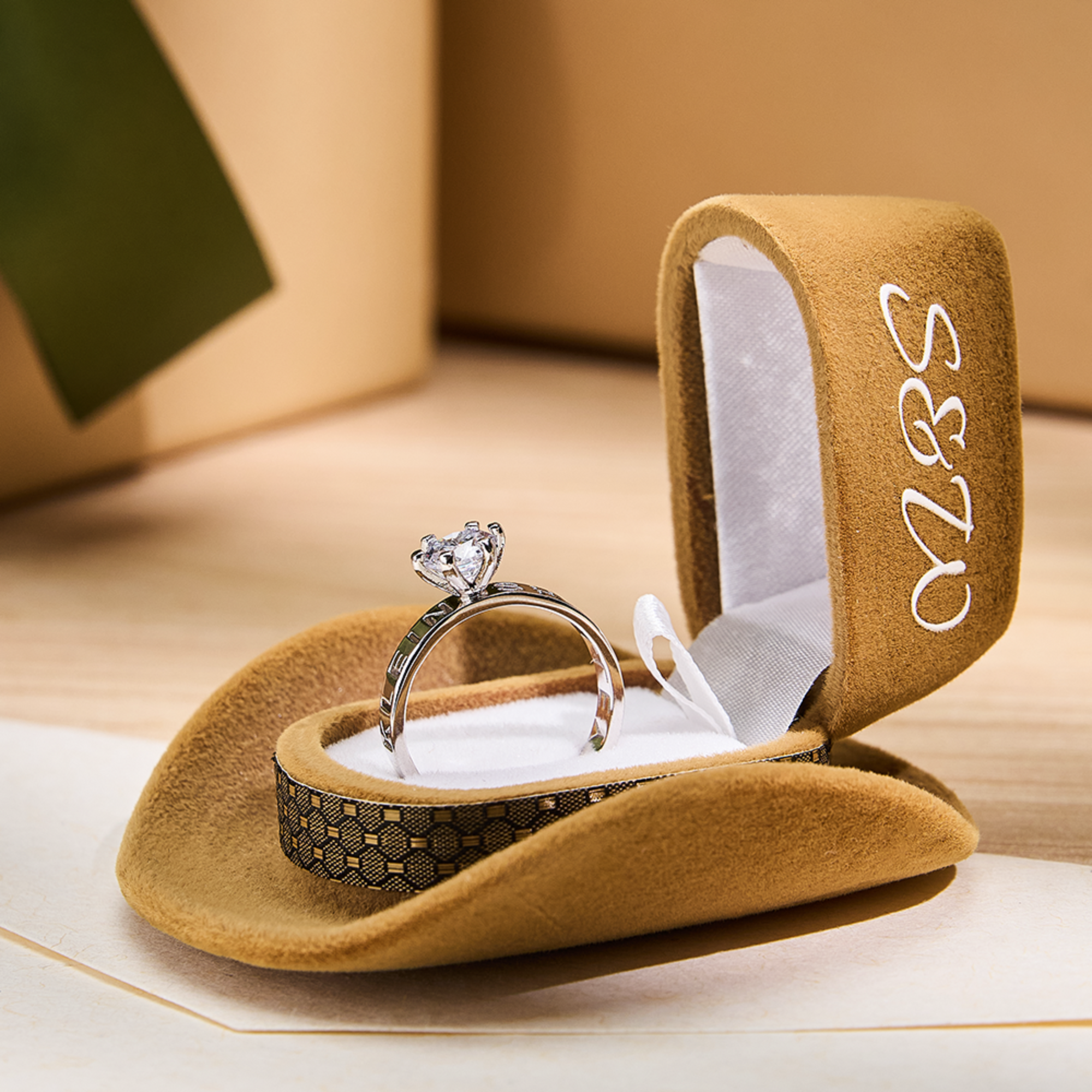 Diamond ring in a brown jewelry box with 'Mr & Mrs' on a wooden surface