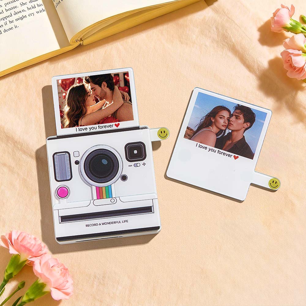 Instant camera with two printed photos on a light surface with flowers around