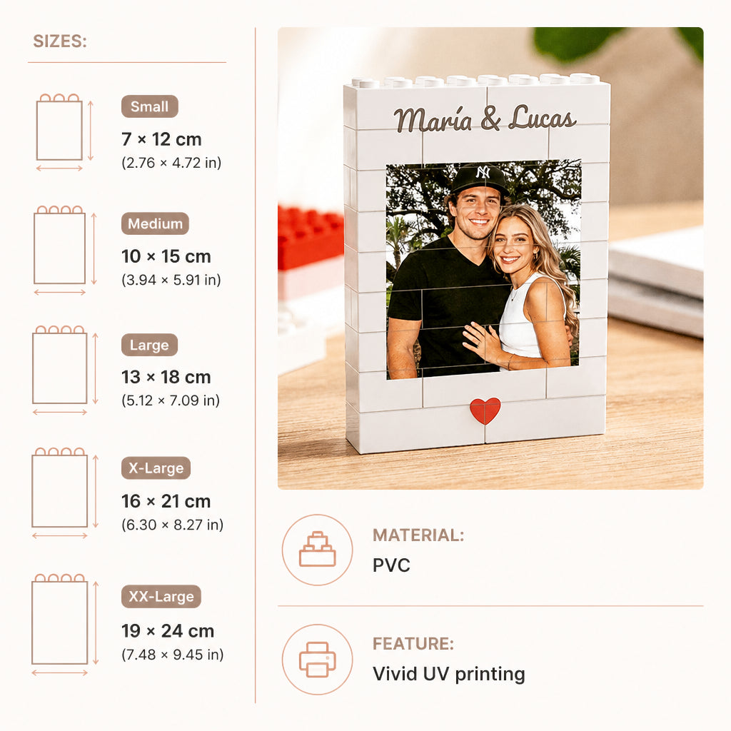 Custom photo print stand designed to look like white LEGO bricks, featuring a customizable photo of a couple, the names 'María & Lucas', and a small red heart at the bottom. The image includes a size guide on the left showing Small, Medium, Large, X-Large, and XX-Large dimensions, along with material and feature icons.
