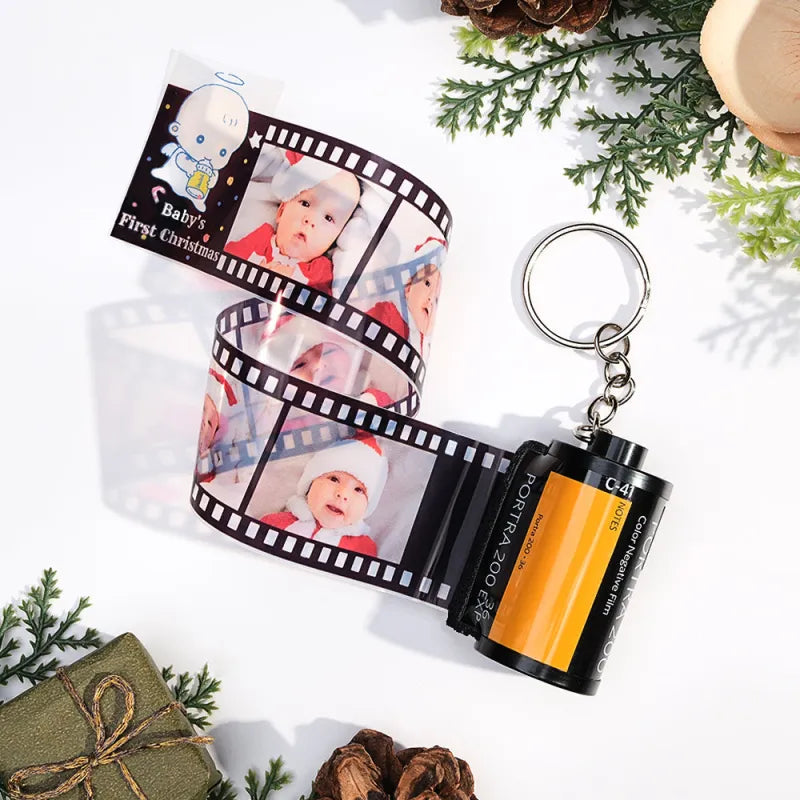 Keychain with photo roll and film canister, featuring a baby's first Christmas theme.