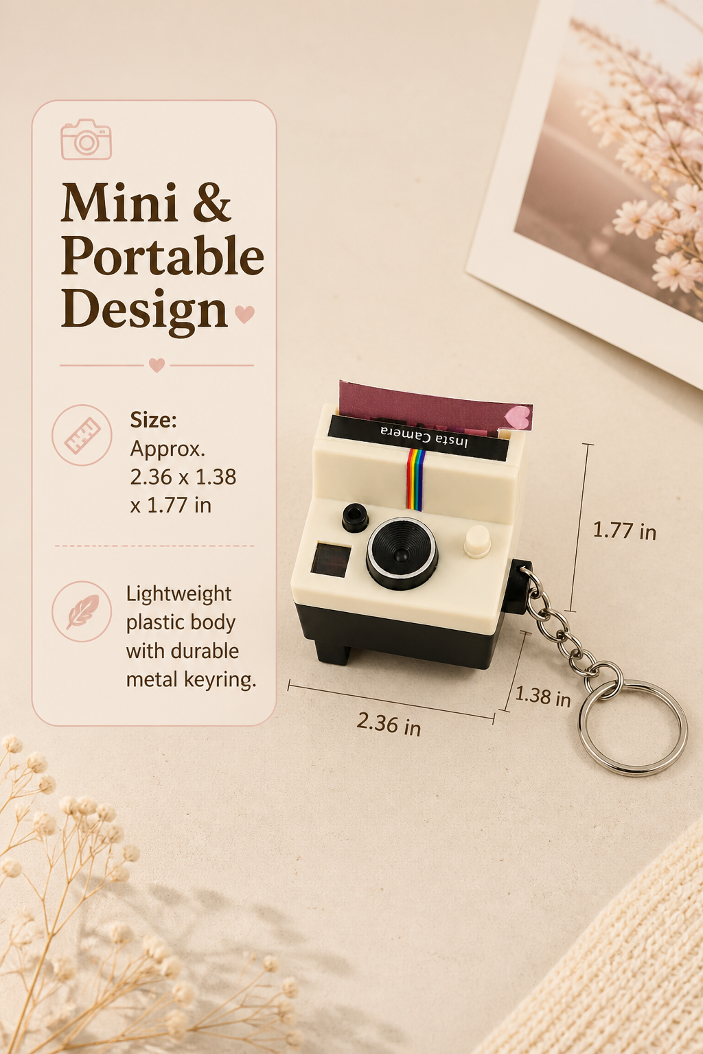 A mini instant camera-shaped keychain shown on a beige styled background with printed dimensions and descriptive text. The keychain is cream and black with a small multicolor stripe and a silver metal keyring attached.